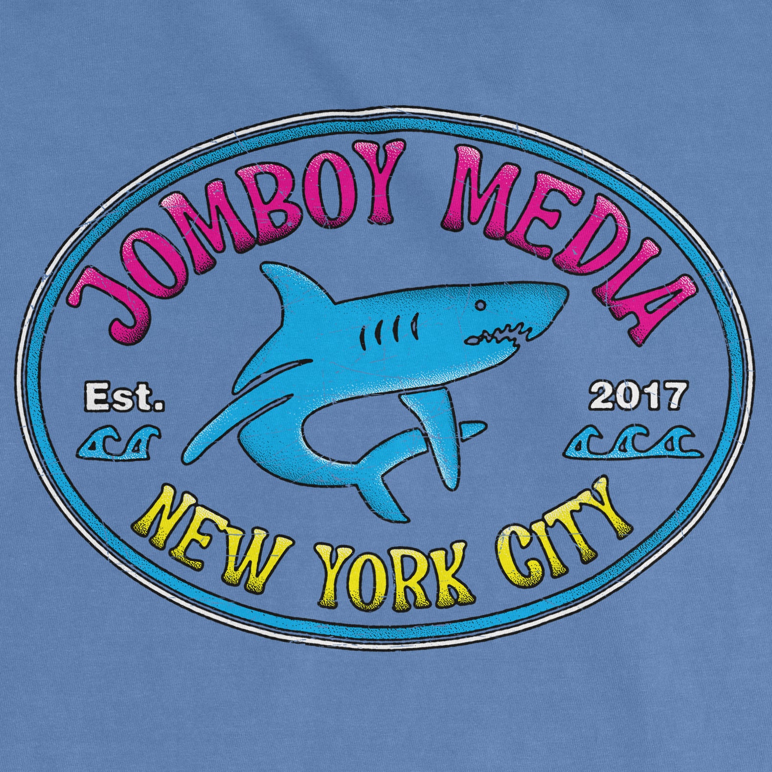 Blue Comfort Colors T-shirt featuring a colorful "Jomboy Media" logo with a shark, waves, and "New York City" text.