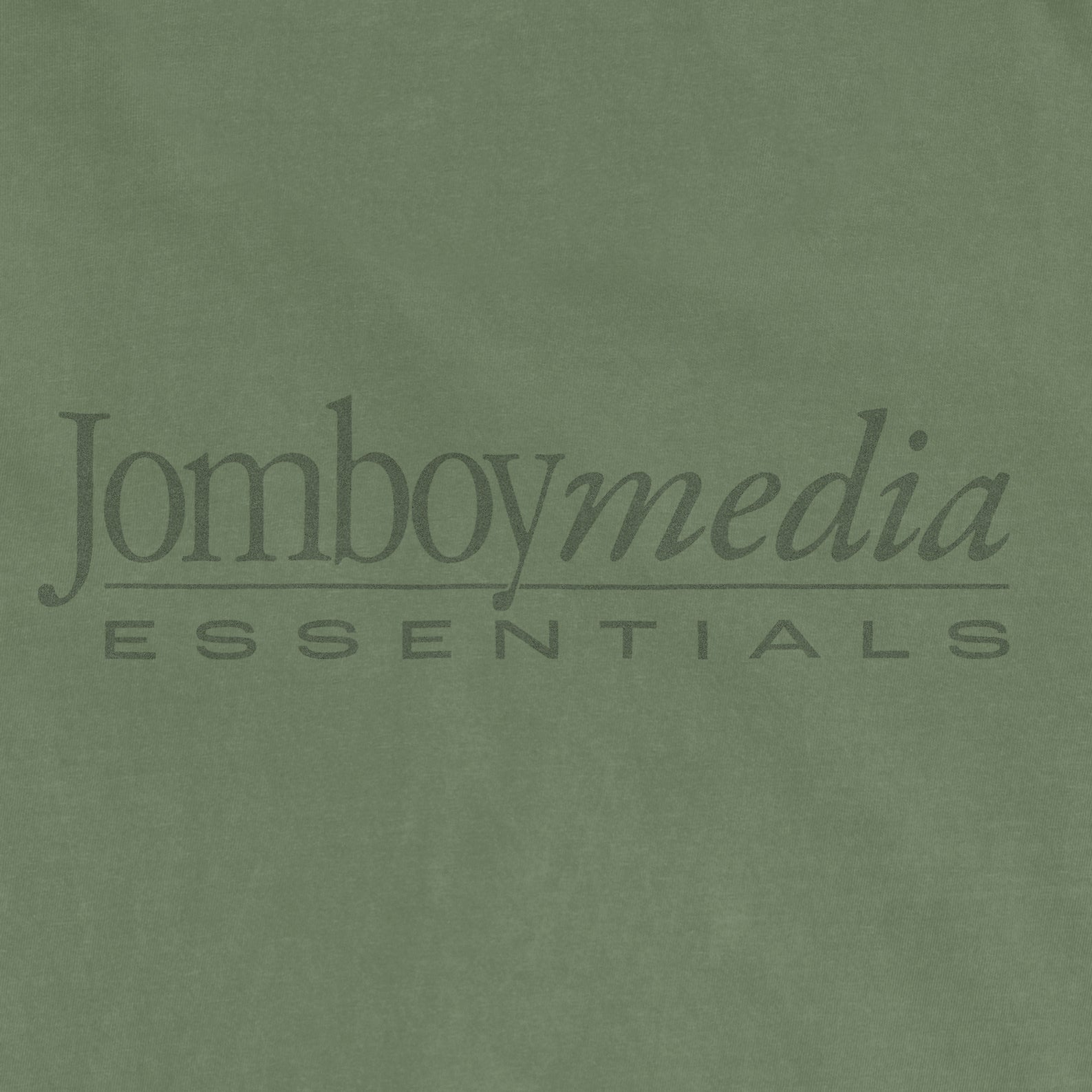 Green fabric with "Jomboy Media Essentials" logo printed in black text.