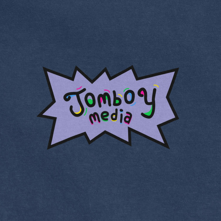 Close-up of a Comfort Colors tee featuring a colorful "Jumbo Media" logo with playful, multicolored text and a comic-style background.