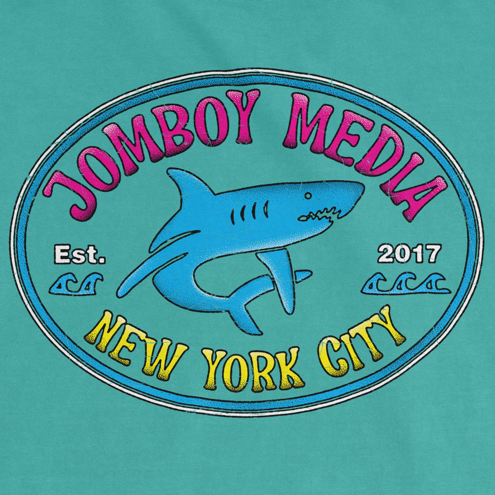 Colorful graphic of a shark with "Jombo Boy Media" text, "Est. 2017," and "New York City" on a teal Comfort Colors tee.
