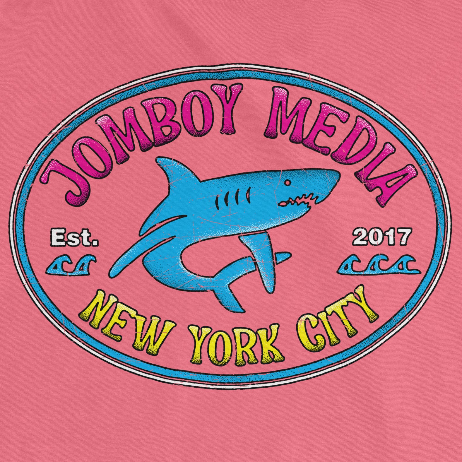 Pink Comfort Colors tee featuring a colorful "Jomboy Media" logo with a shark graphic, "New York City" text, and established date.