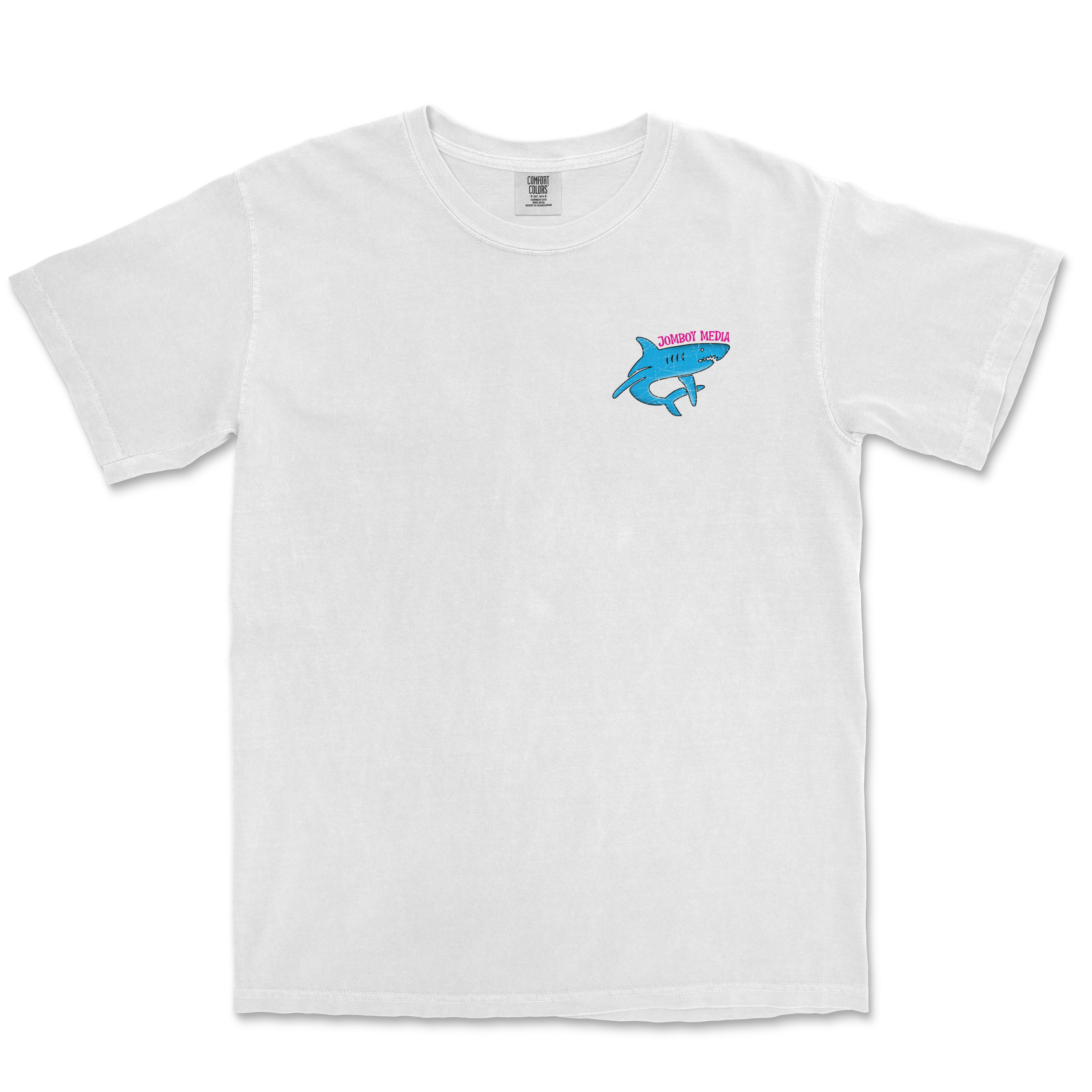 White Comfort Colors tee featuring a small blue shark graphic on the chest with pink "Jomboy Media" text above it.