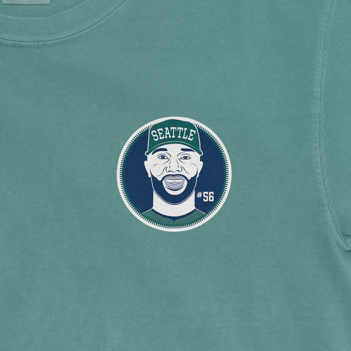 Close-up of a teal Randy Arozarena shirsey featuring a circular graphic of a smiling man wearing a Seattle cap, with "#56" on the side.