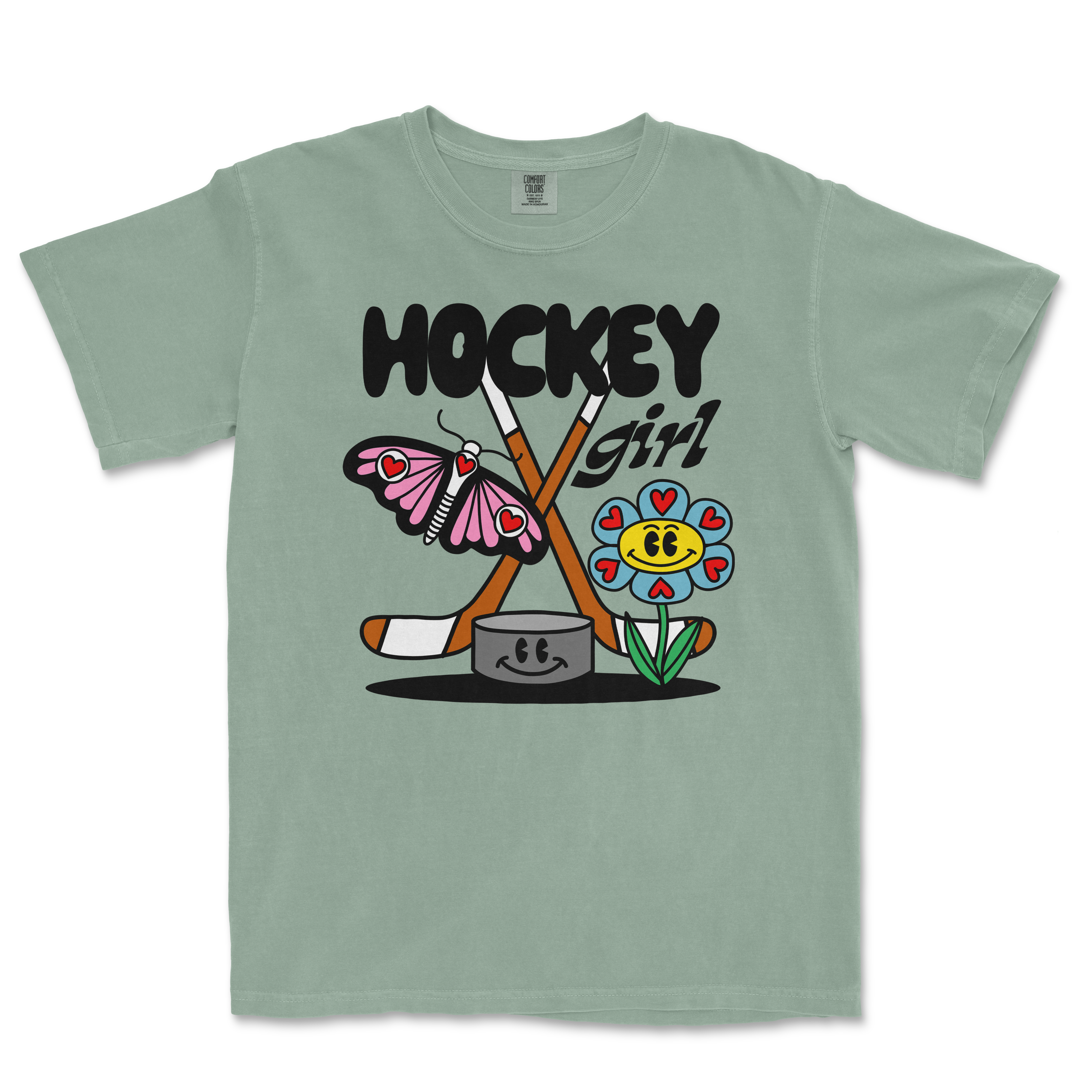 Light green Comfort Colors tee featuring a colorful cartoon design of a butterfly, flower, hockey sticks, and the text "Hockey Girl.