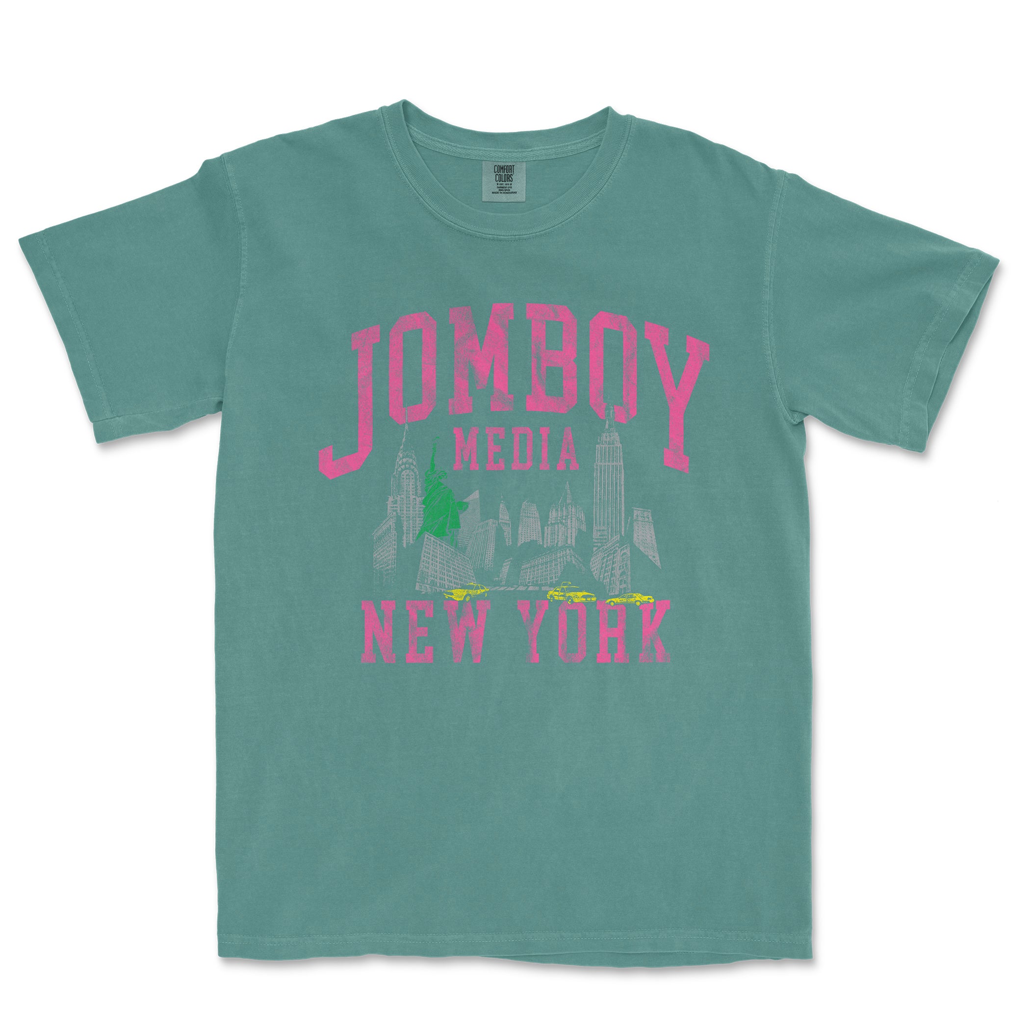 Comfort Colors teal T-shirt featuring a vintage 90s-inspired graphic of New York City with pink "JOMBOY MEDIA" text.