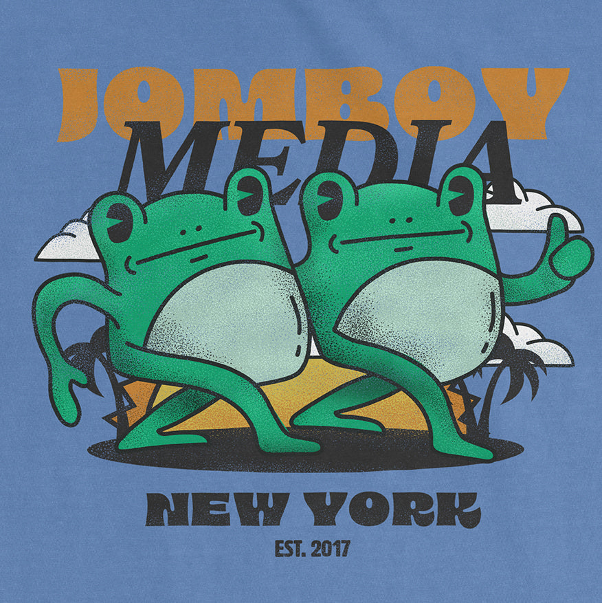 Comfort Colors tee featuring two cartoon frogs with "Jomby Media" text, "New York" and "Est. 2017" on a blue background.