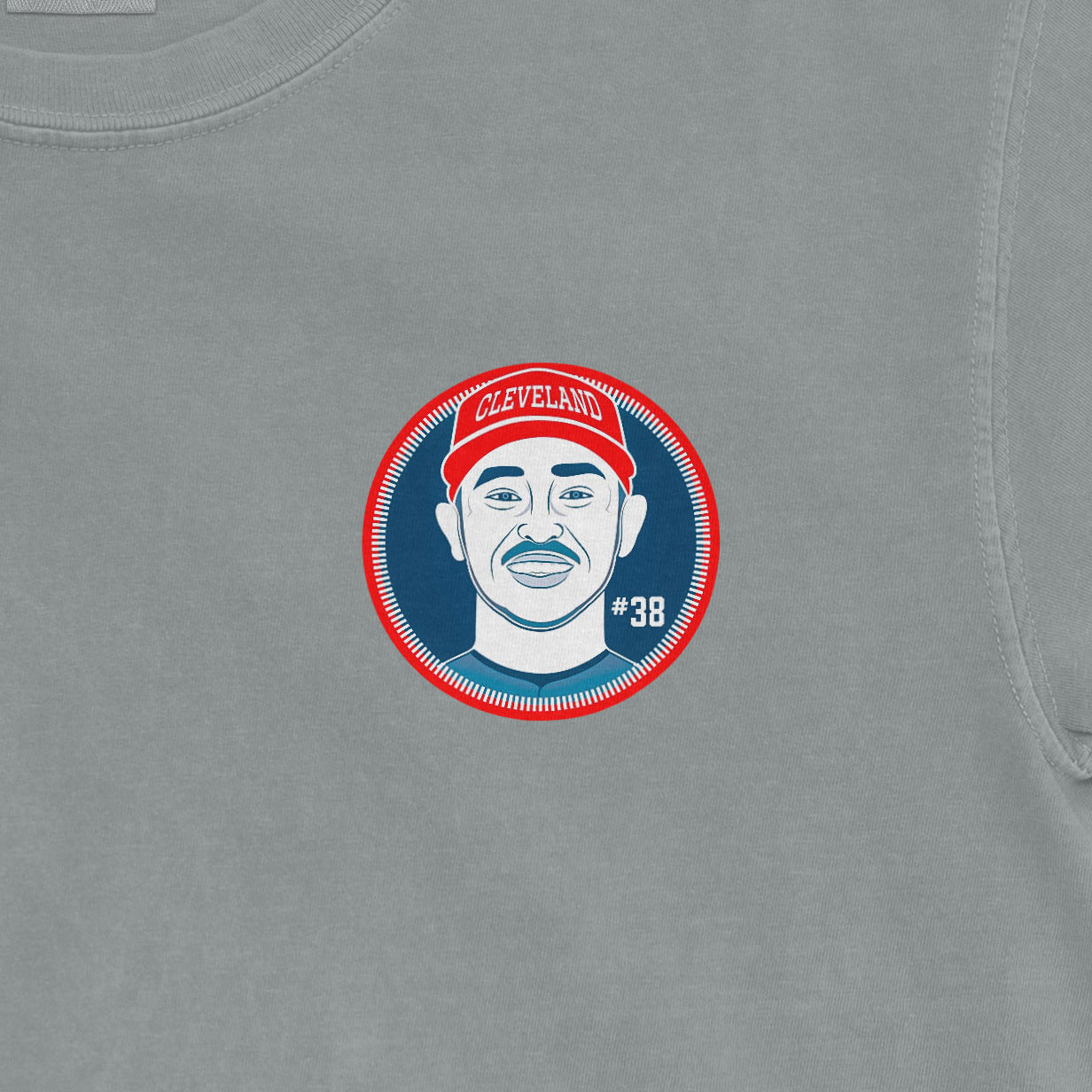 Close-up of a gray shirt featuring a graphic of a man wearing a red Cleveland cap, with "#38" on the lower right.