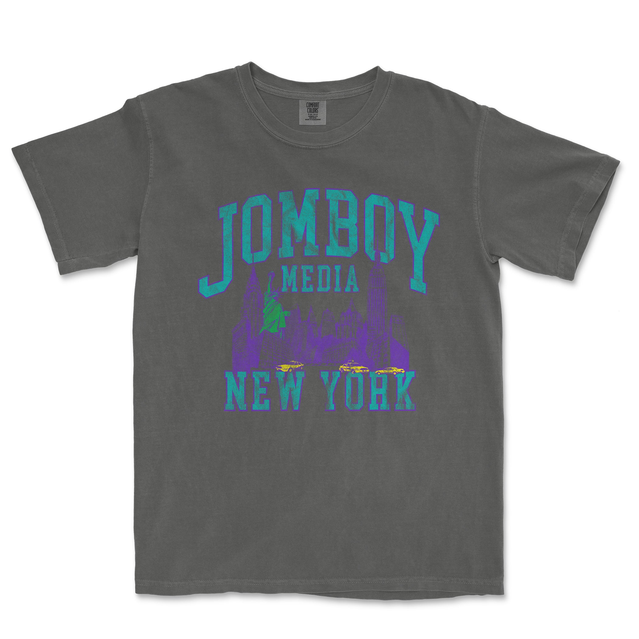 Gray Comfort Colors tee featuring a colorful 90s-inspired JOMBOY MEDIA New York graphic design with cityscape and taxis.