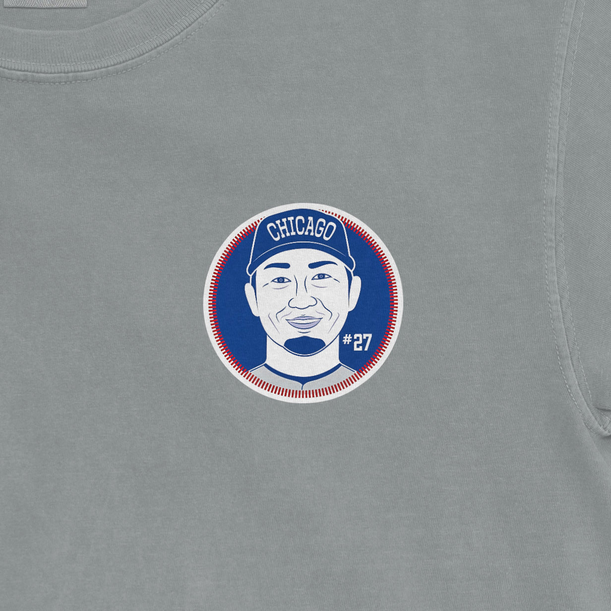 Close-up of a gray Seiya Suzuki Shirsey featuring a circular graphic of a smiling player wearing a Chicago cap, with "#27" displayed.