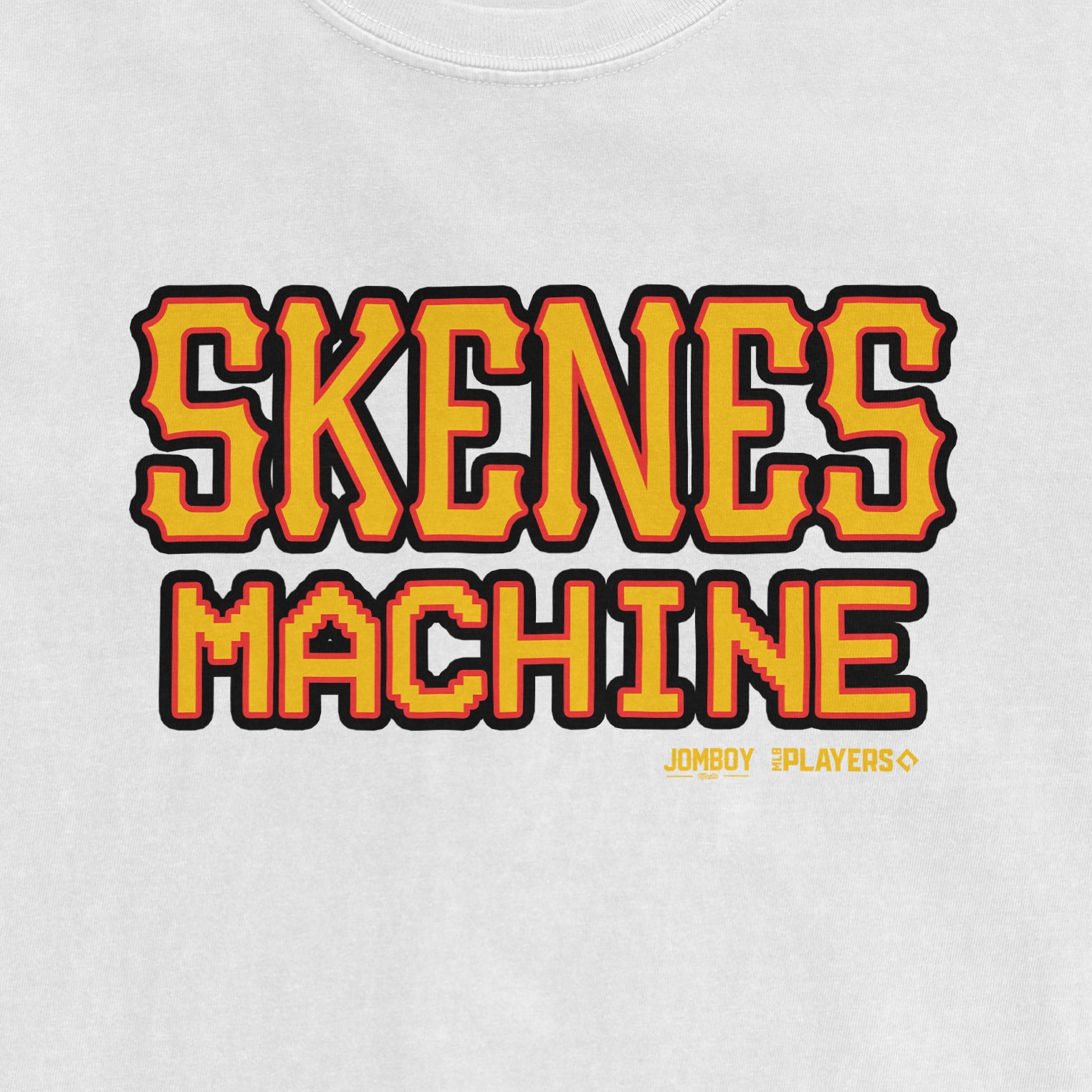 White T-shirt featuring bold, pixelated yellow and red text that reads "SKENES MACHINE" with small logos for JOMBOY and PLAYERS below.