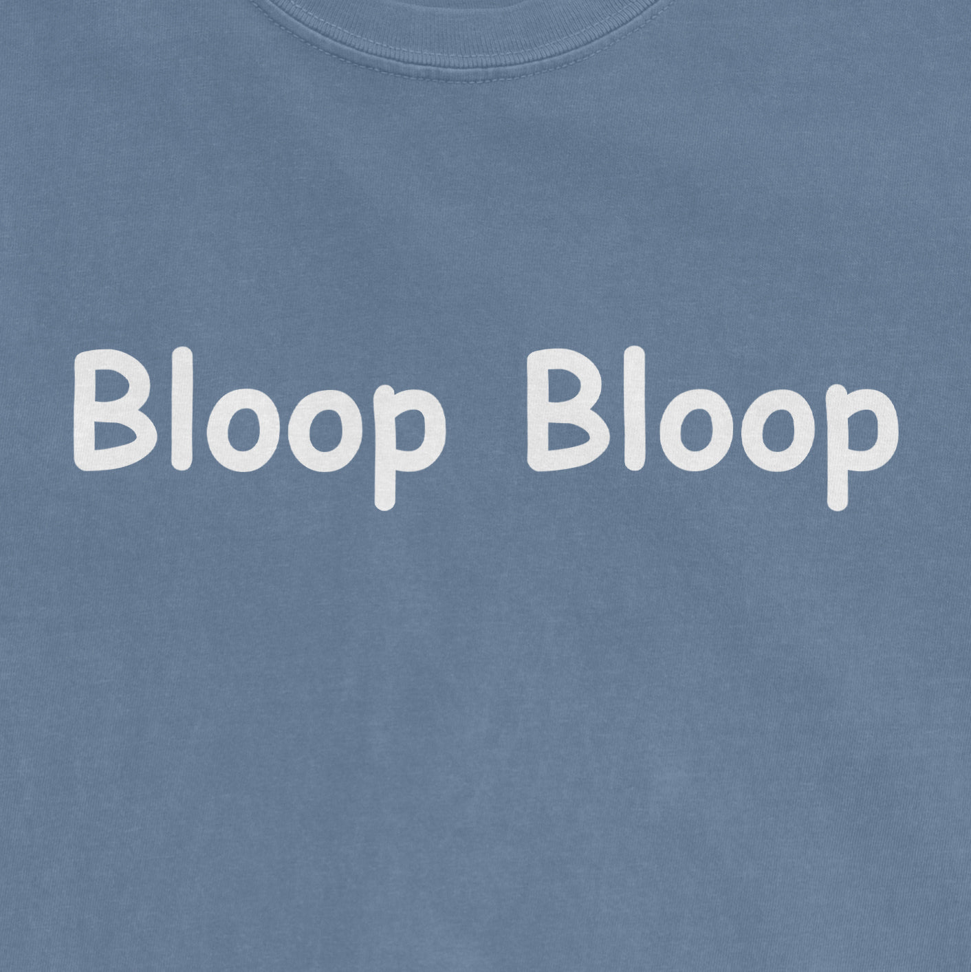 Close-up of a blue Comfort Colors T-shirt with white text that reads "Bloop Bloop" in a playful, rounded font.