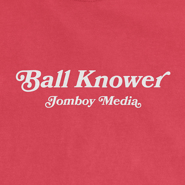Pink Comfort Colors T-shirt with white text reading "Ball Knower" and "Jomboy Media" in stylish fonts.