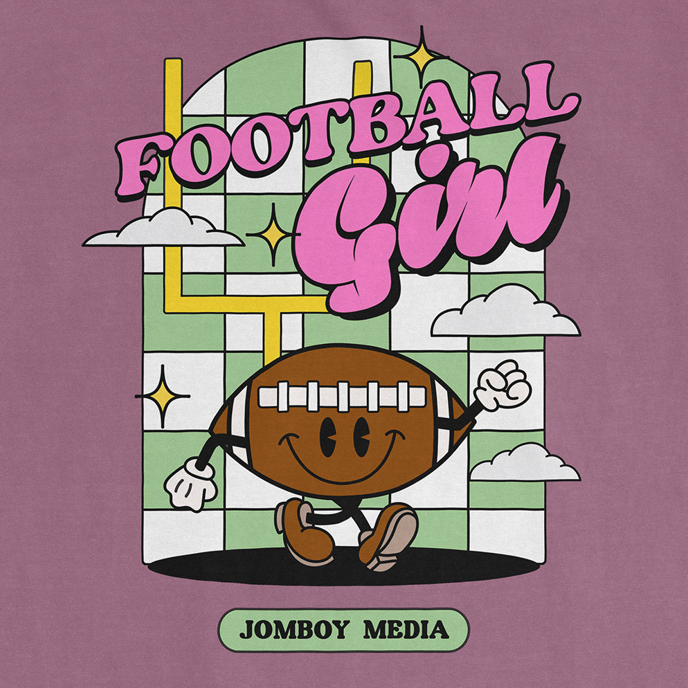 Comfort Colors tee featuring a cartoon football character with a smiling face, arms, and legs, with "Football Girl" text and playful background.