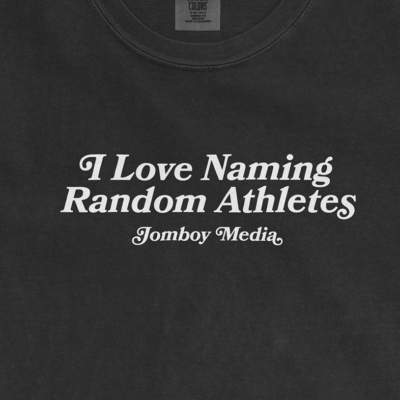 Black Comfort Colors T-shirt with white text that reads, "I Love Naming Random Athletes" and "Jomboy Media" below.