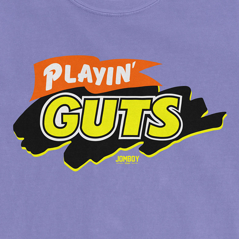 Bright purple T-shirt featuring a bold graphic logo with "PLAYIN' GUTS" in large yellow and white letters, and "JOMBOY" underneath.