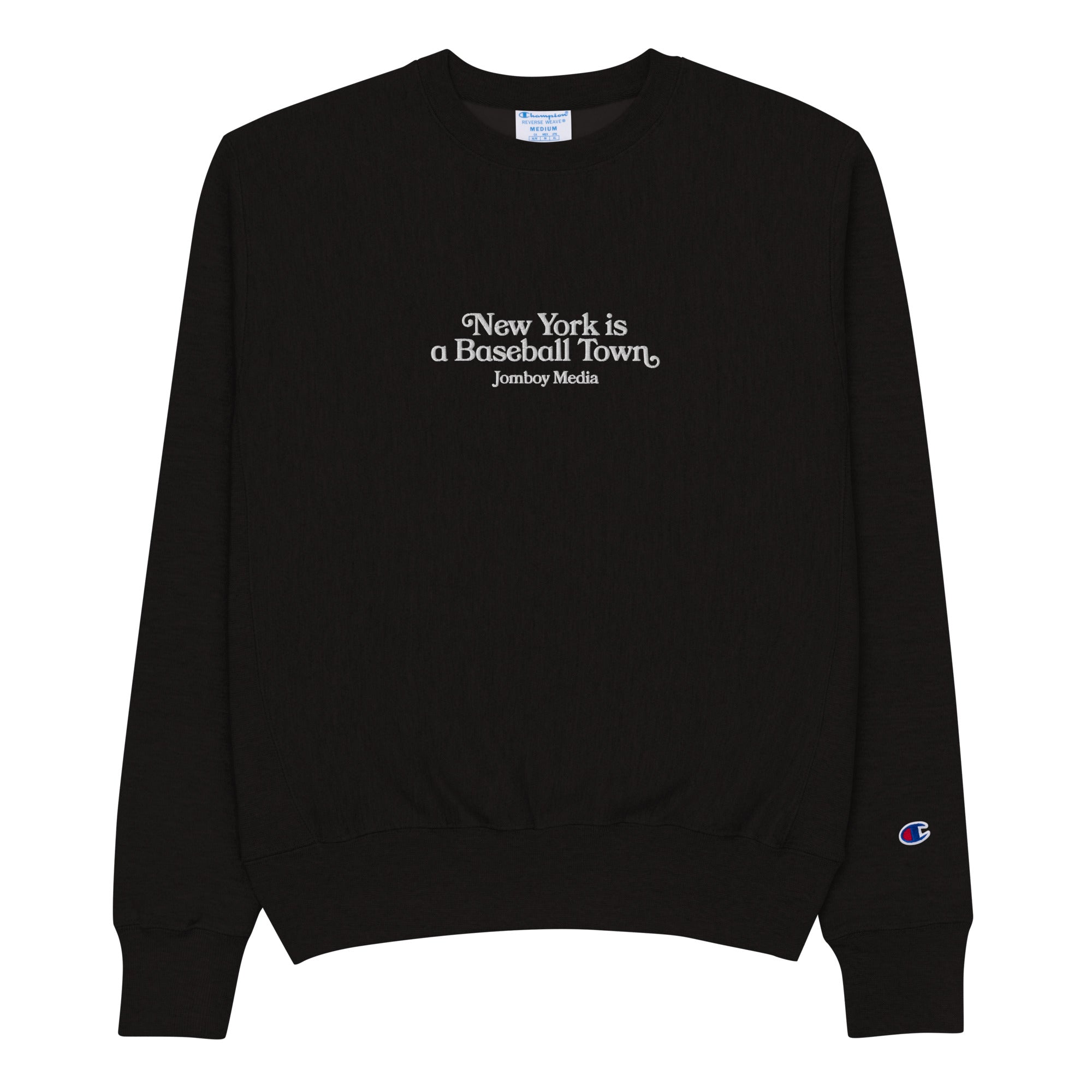 Black heavy-duty crewneck sweatshirt with white embroidered text: "New York is a Baseball Town" and "Jomboy Media," featuring a small Champion logo on the sleeve.