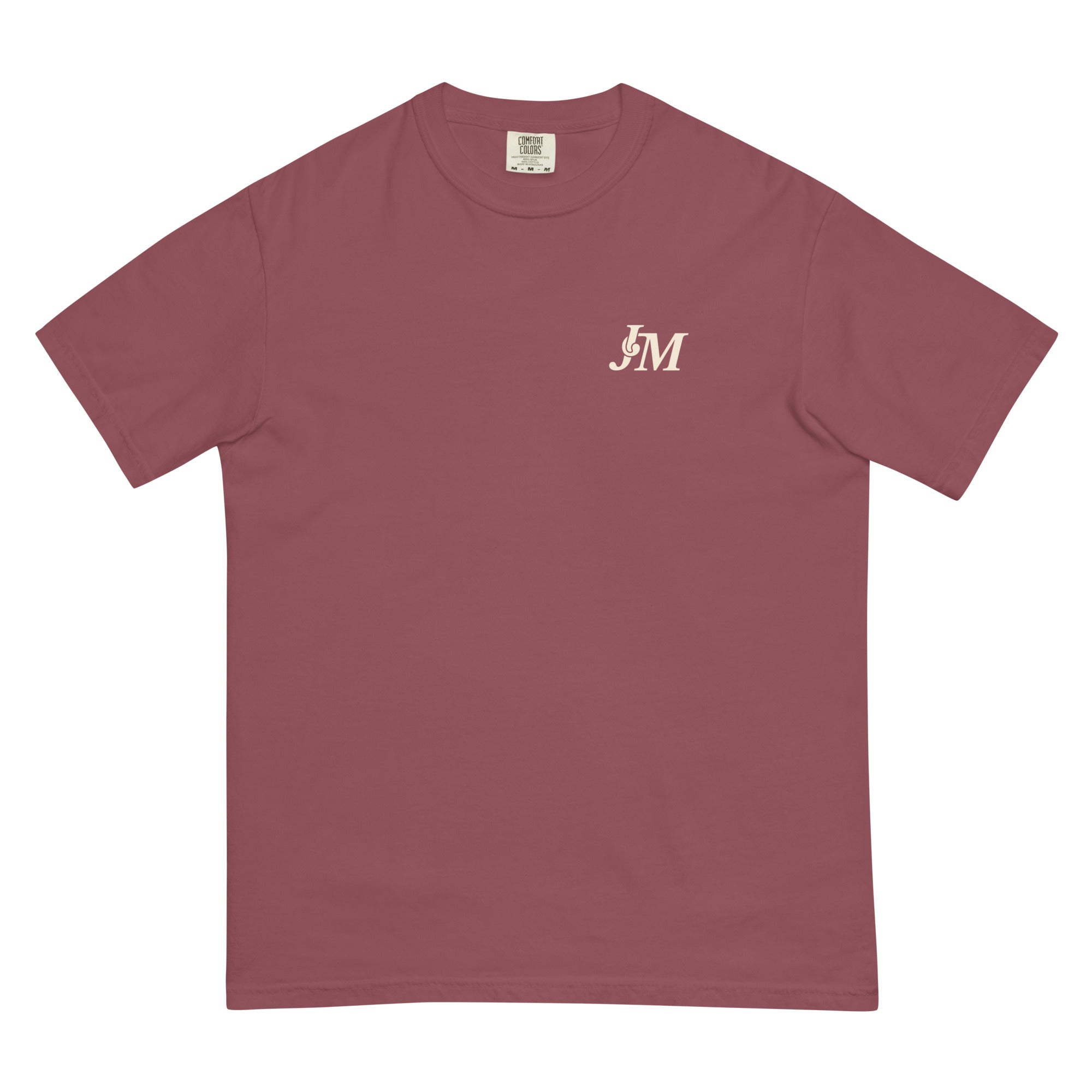 A pink T-shirt featuring a small "JM" logo in white on the upper left chest area.