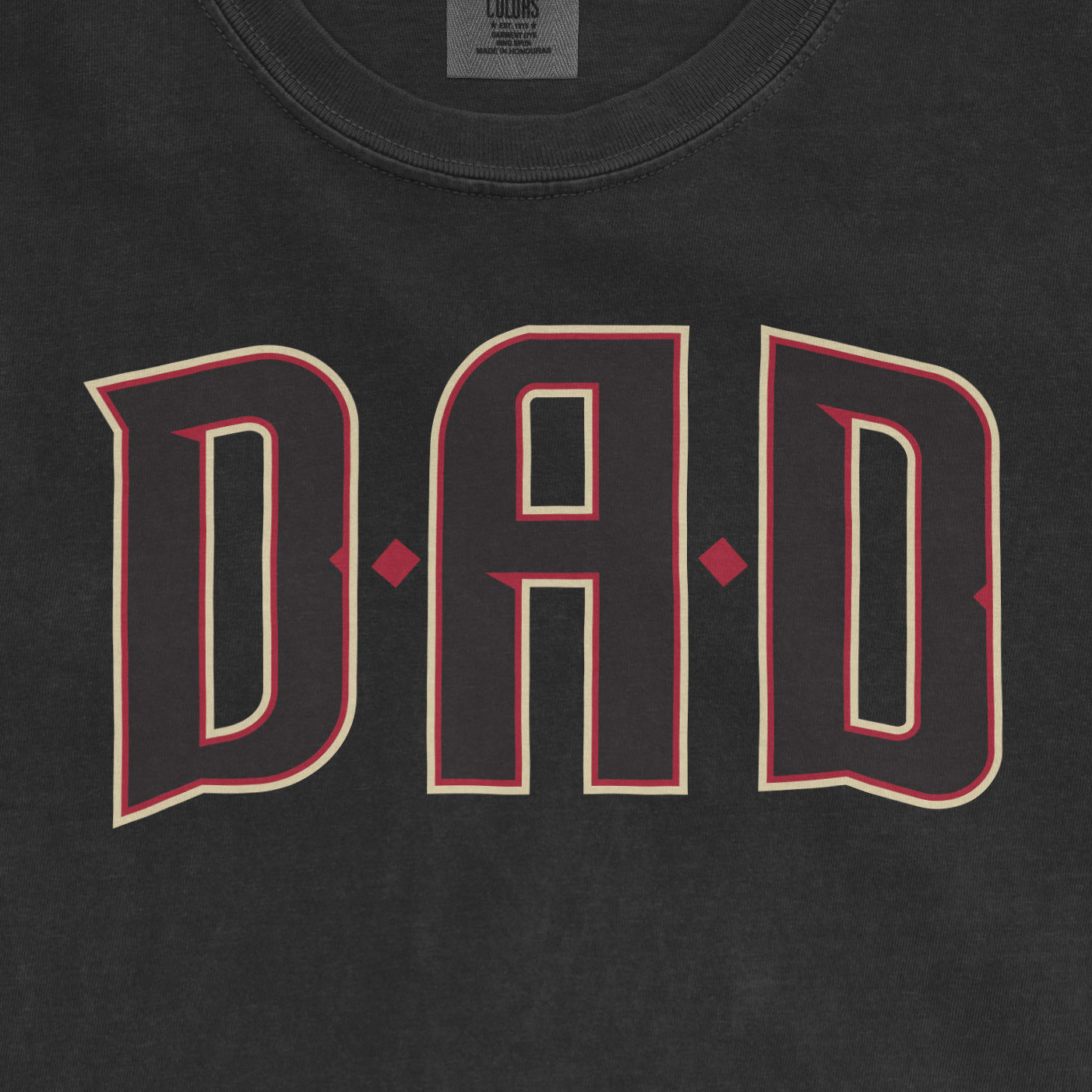 Black Comfort Colors T-shirt with "DAD" outlined in beige and red, celebrating Arizona baseball dads.
