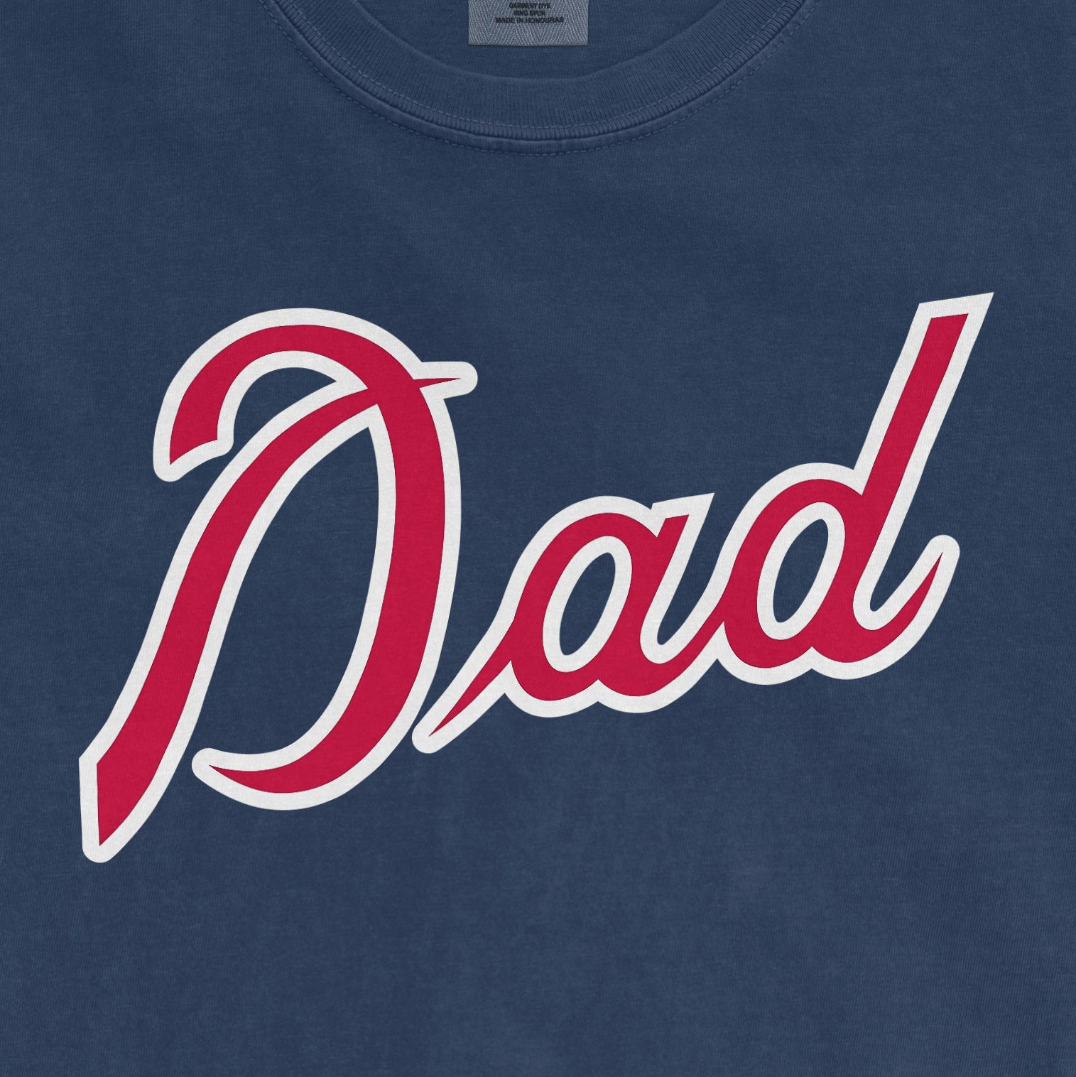 Close-up of a blue Comfort Colors T-shirt with "Dad" written in red and white script, celebrating Atlanta baseball dads.