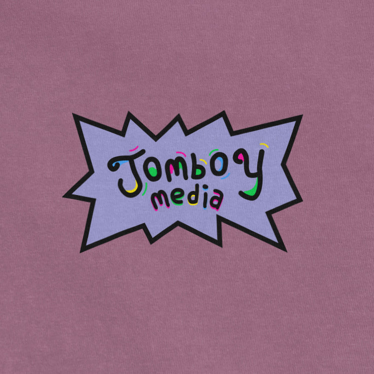 Colorful "Jomboy Media" logo on a pink Comfort Colors T-shirt, featuring playful, multicolored text inside a comic-style burst.