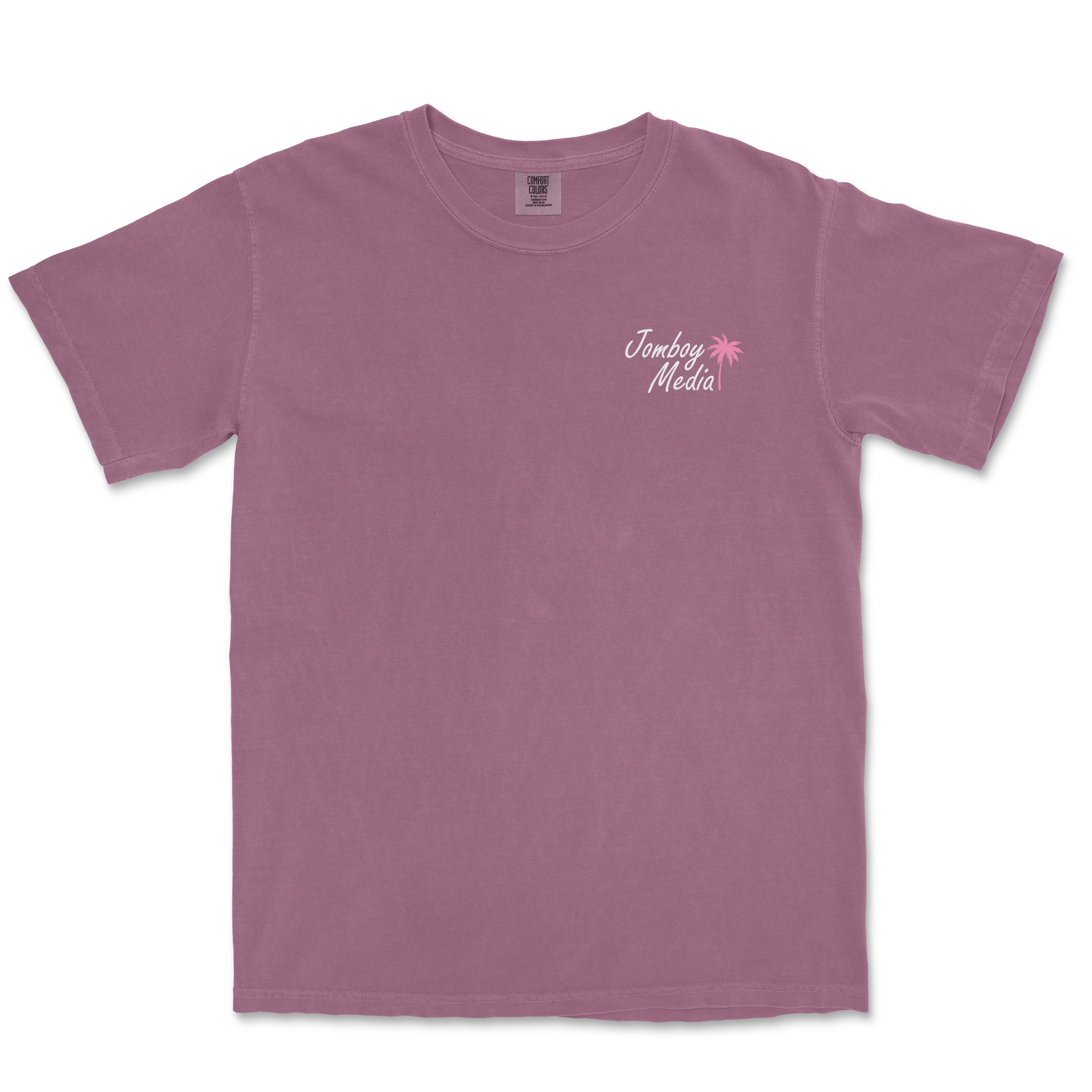 Pink Comfort Colors T-shirt with "Jomboy Media" text and a pink palm tree graphic on the upper left chest.