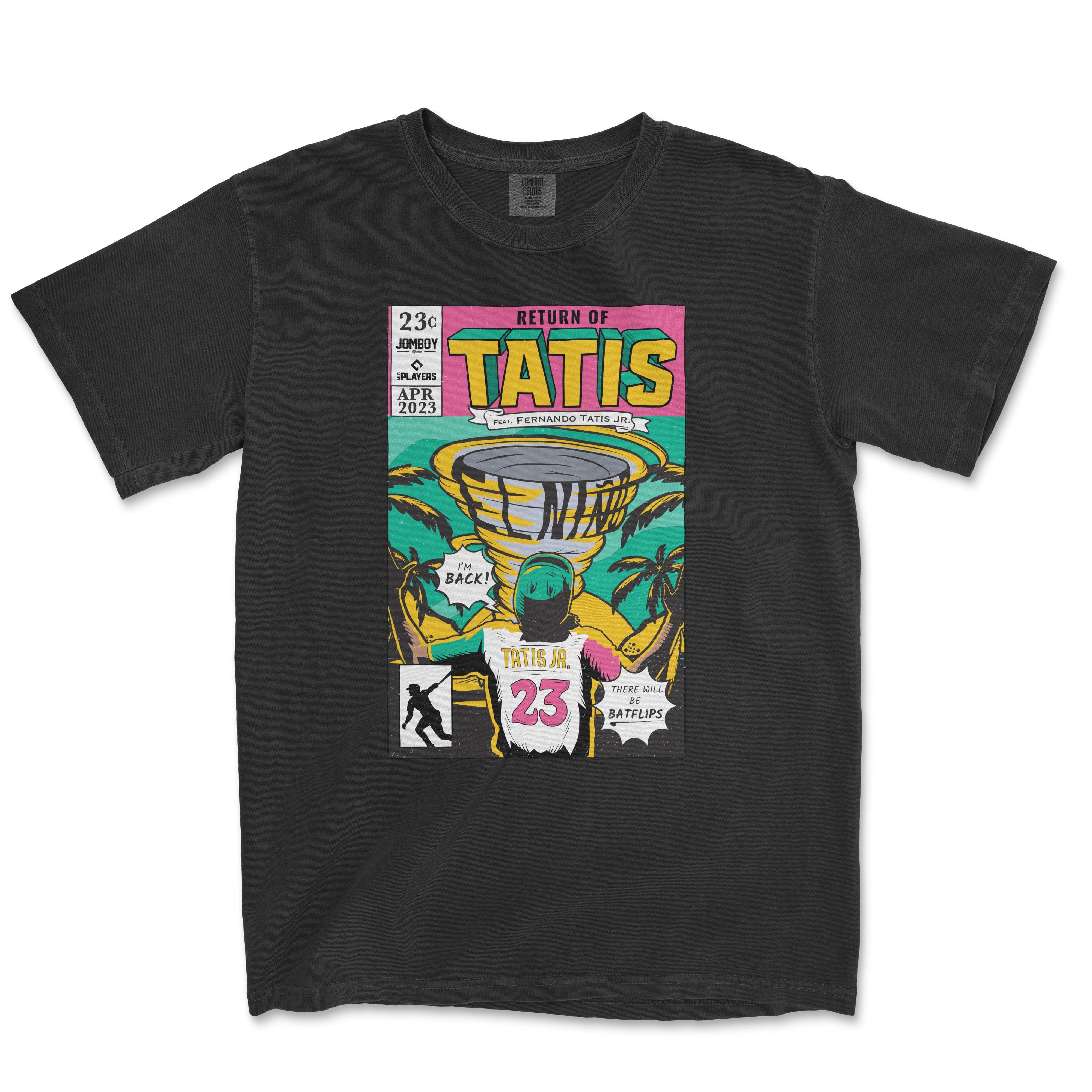 Black Comfort Colors t-shirt featuring a vibrant comic book style print with "Return of Tatis" theme, showcasing a cartoon illustration of Fernando Tatis Jr., tropical palm trees, and baseball elements, marked with the text "Tatis Jr. 23