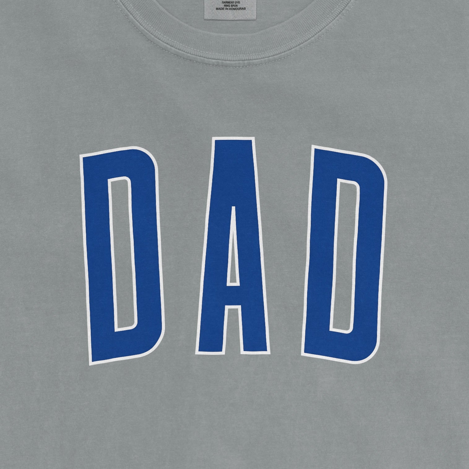 Comfort Colors tee with "DAD" printed in bold blue letters on a gray background.