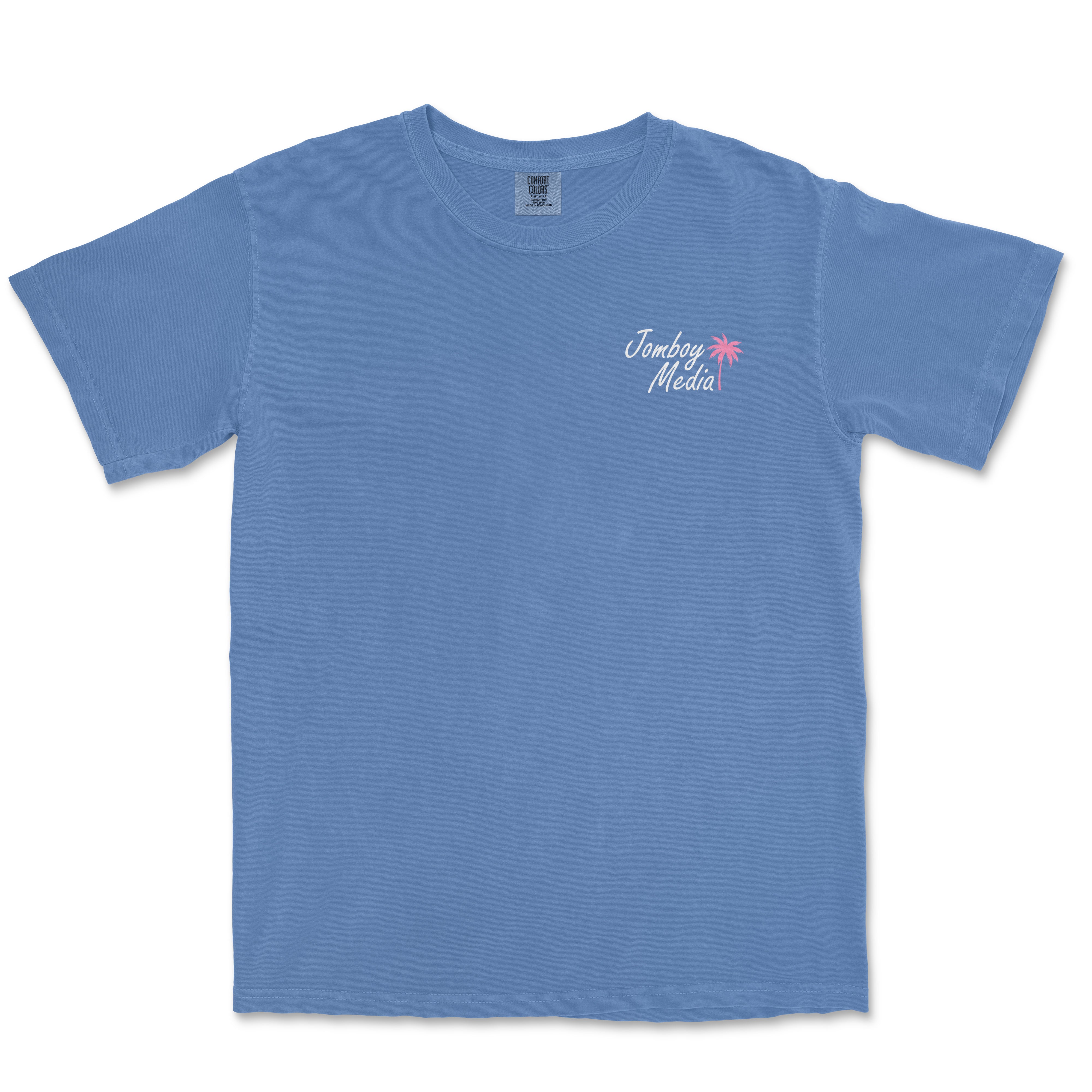 Blue Comfort Colors tee with "Greetings from Jomboy Media" text and pink palm tree graphic on the chest.