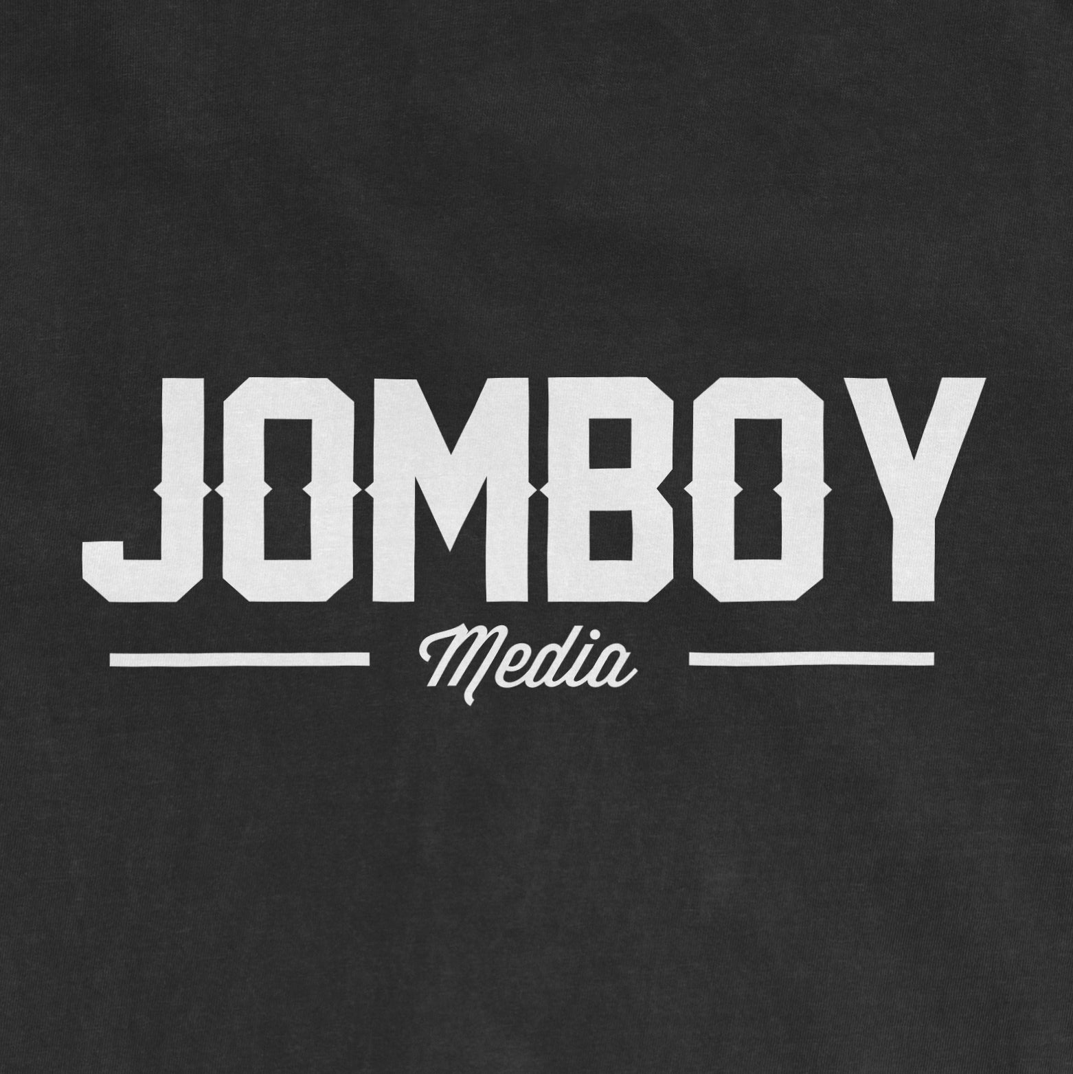Black Comfort Colors T-shirt featuring a white "Jomboy Media" logo with bold uppercase text and a cursive "Media" underneath.