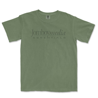Green vintage-style T-shirt with "Jomboymedia Essentials" logo printed across the chest, inspired by 1980s fashion.