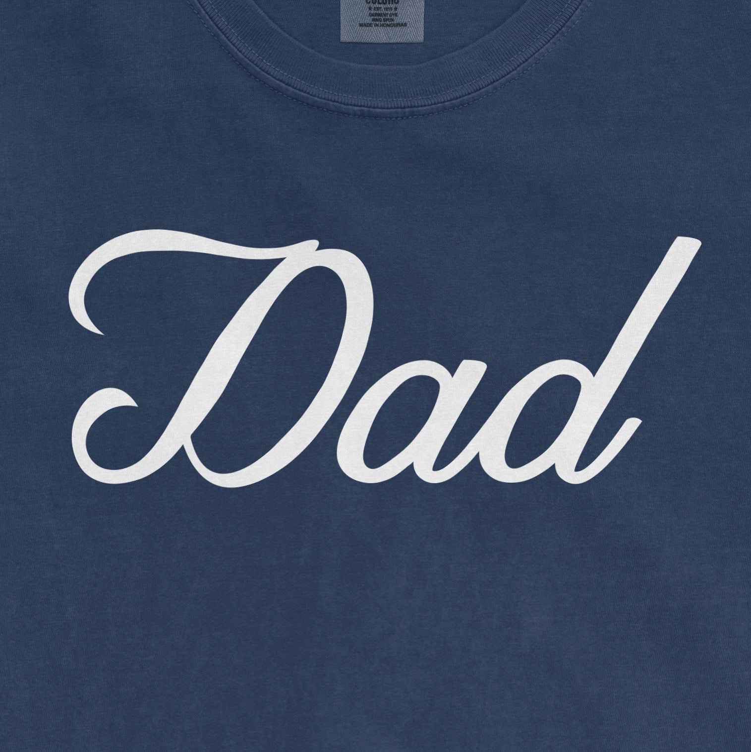 Blue Comfort Colors T-shirt with white "Dad" text in cursive font, designed for Bronx baseball dads.