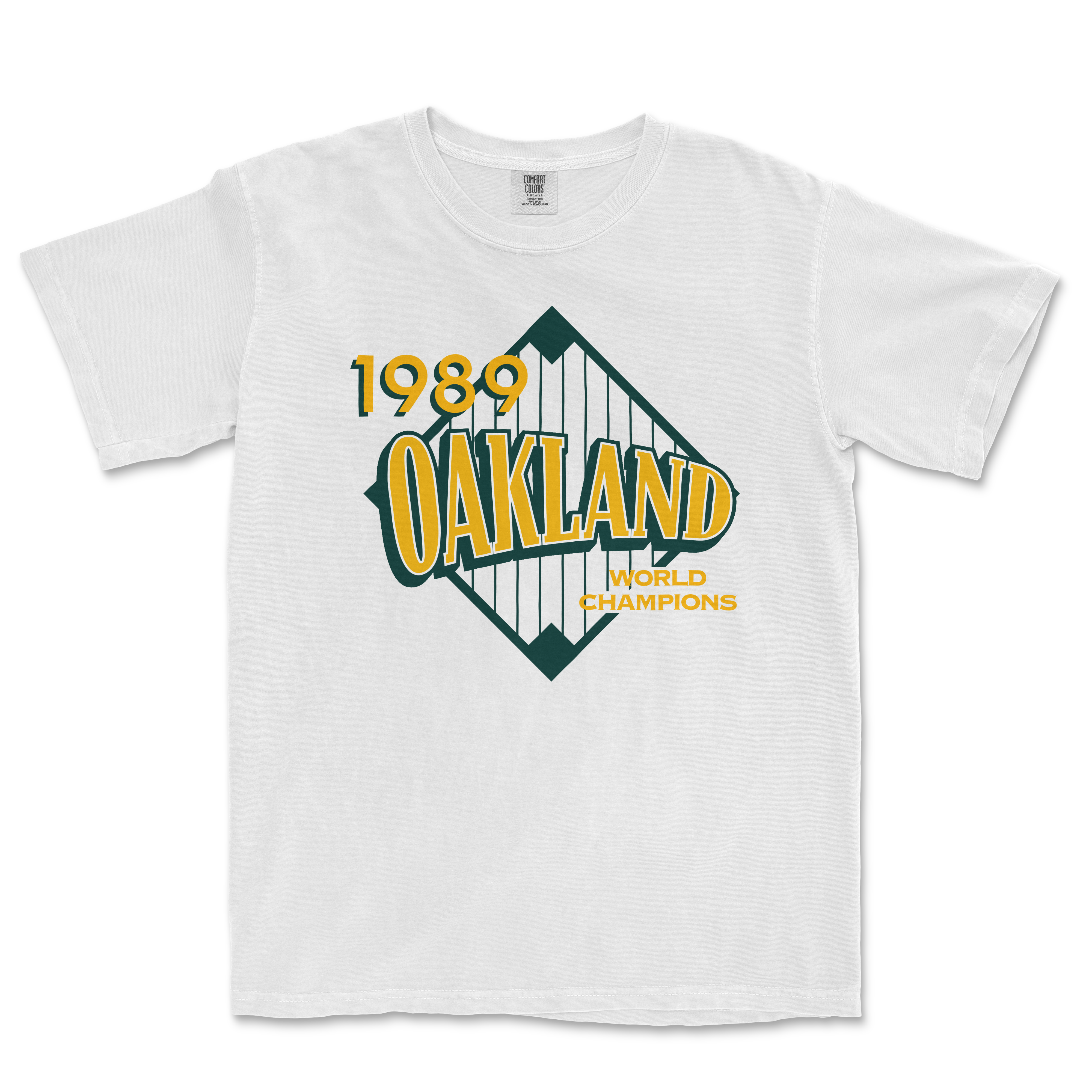 White Comfort Colors tee featuring a vintage Oakland 1989 World Champions graphic with yellow and green text and design.