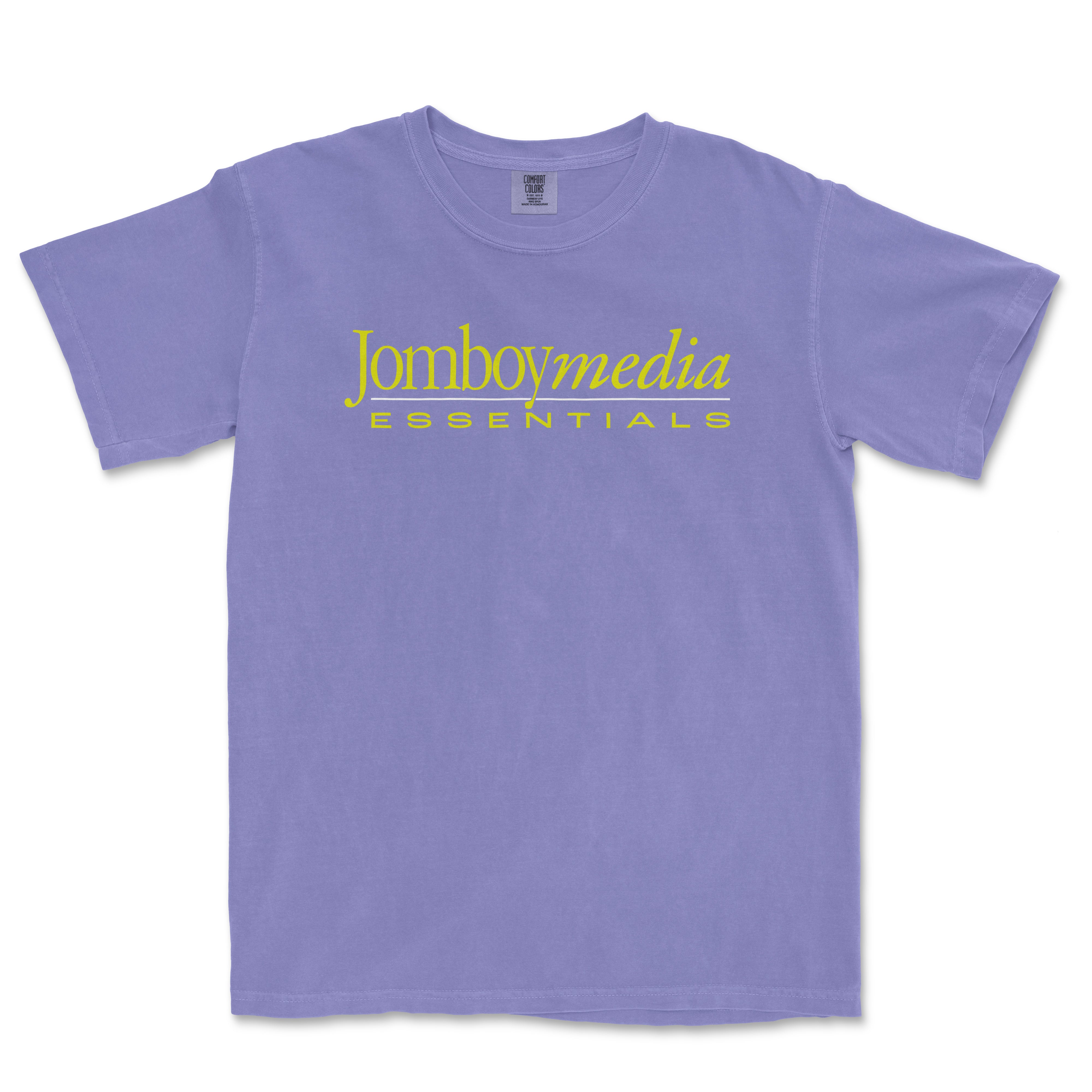 Purple T-shirt with "Jomboymedia ESSENTIALS" logo in yellow text across the front, styled in a vintage '80s design.