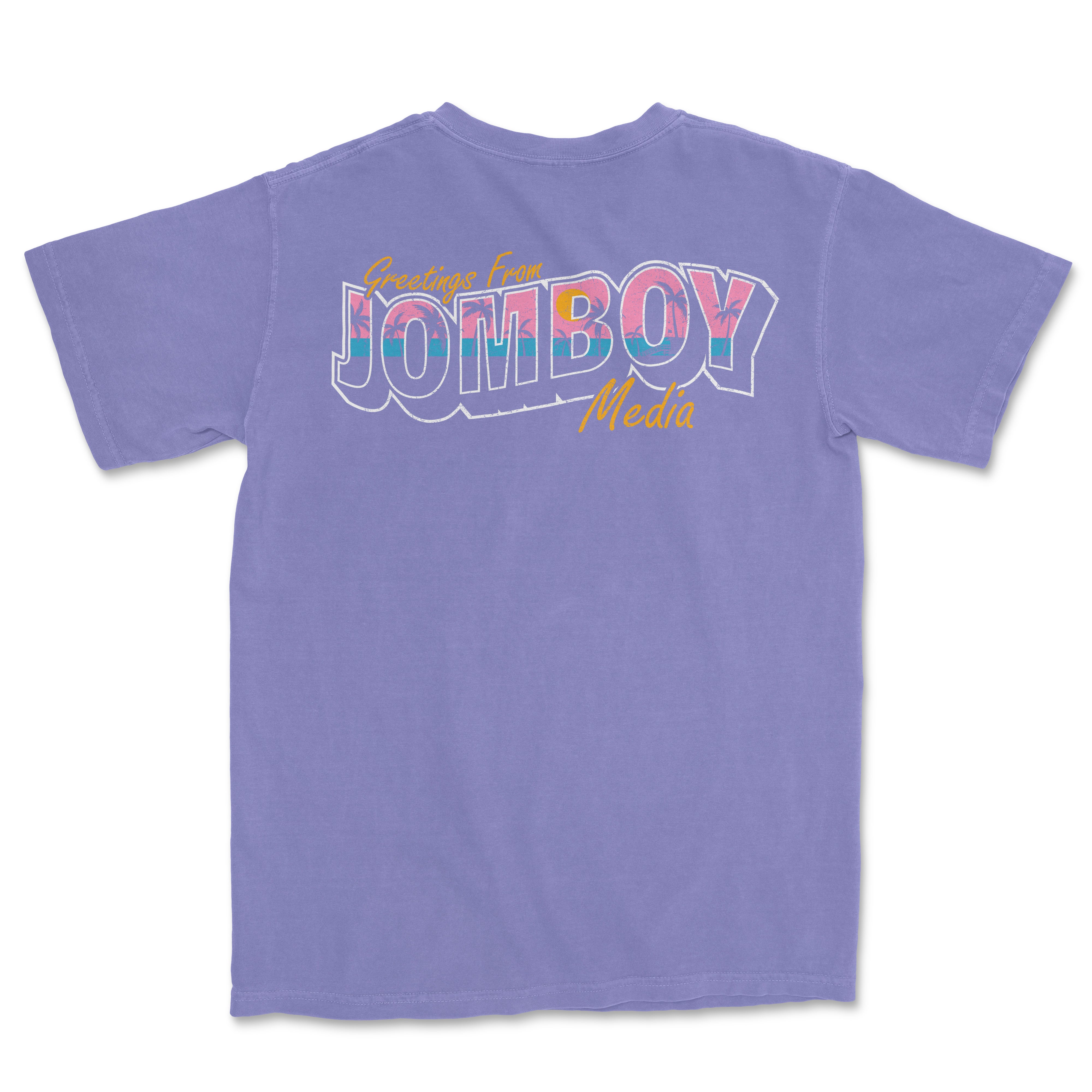 Purple Comfort Colors T-shirt with colorful "Greetings from Jomboy Media" graphic and yellow cursive text.