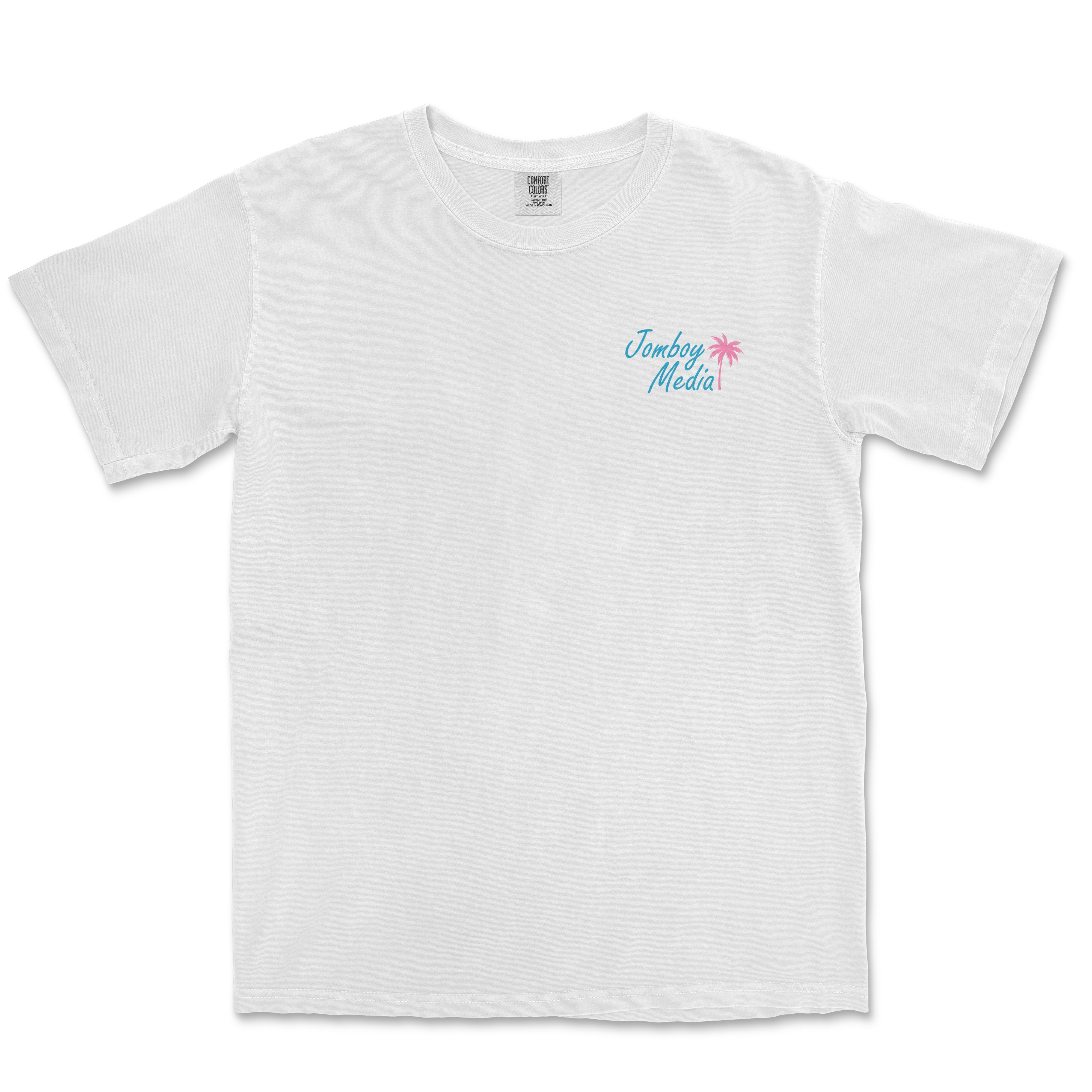 White Comfort Colors T-shirt featuring a small "Jomboy Media" logo with blue text and a pink palm tree on the upper left chest area.