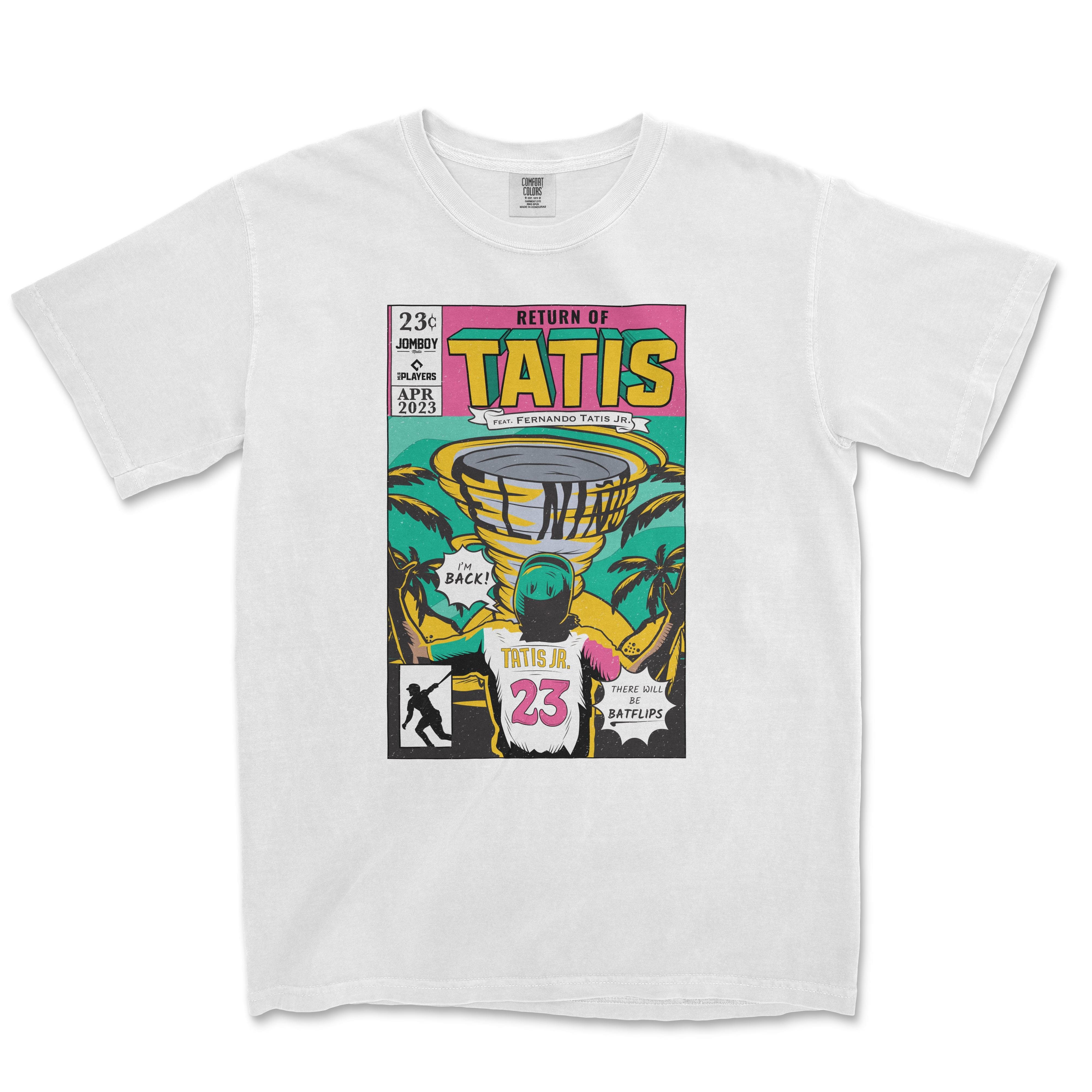 Alt text: "White Comfort Colors tee featuring the 'Return of Tatís' comic book cover design with vibrant illustrations of Fernando Tatís Jr., tropical imagery, and baseball elements, dated April 2023."