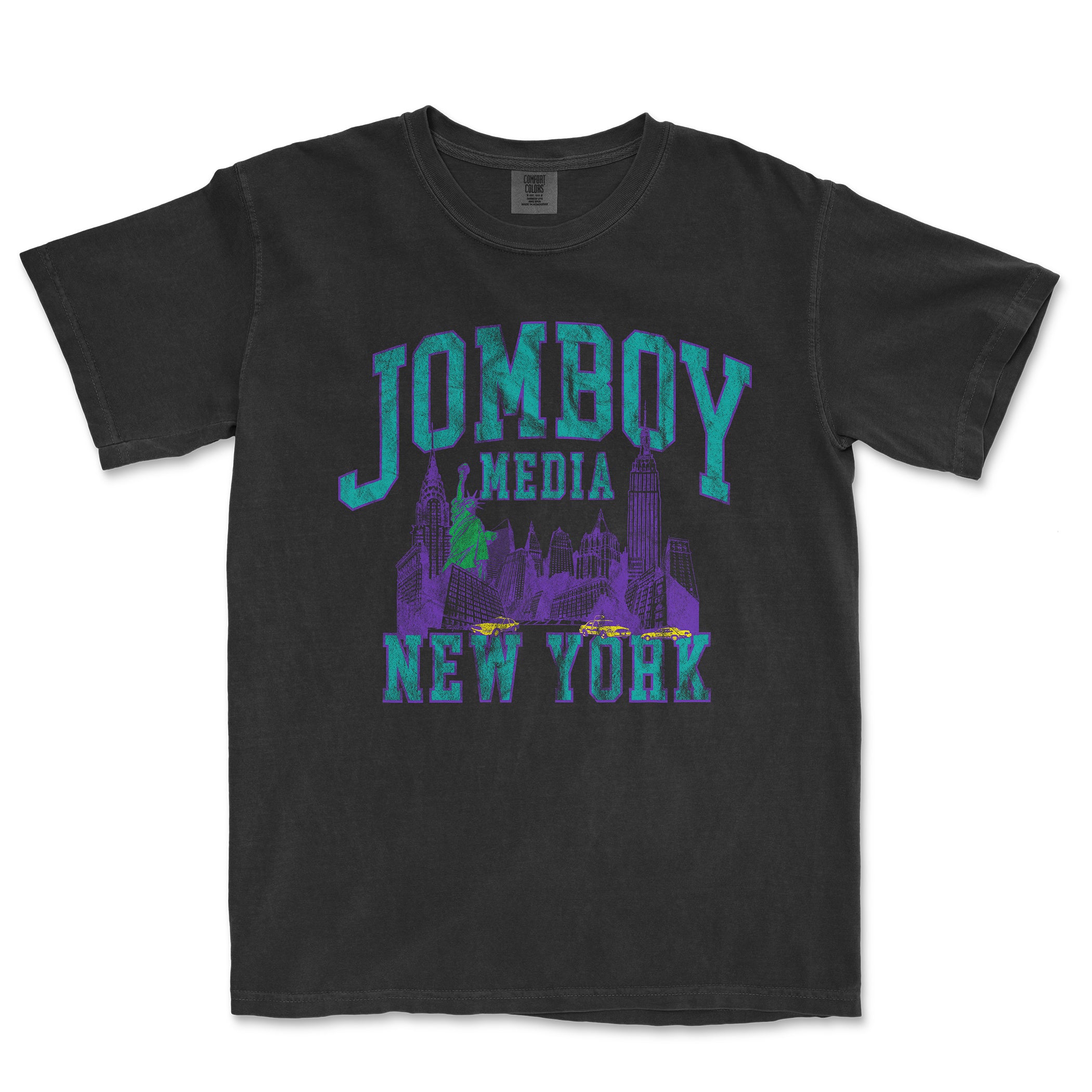 Black Comfort Colors T-shirt featuring a colorful 90s-inspired graphic of New York City skyline, with "JOMBOY MEDIA" text in bold purple and teal.