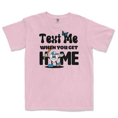 Pink T-shirt with a cartoon character holding a baseball bat, surrounded by playful text that reads "Text me when you get home.