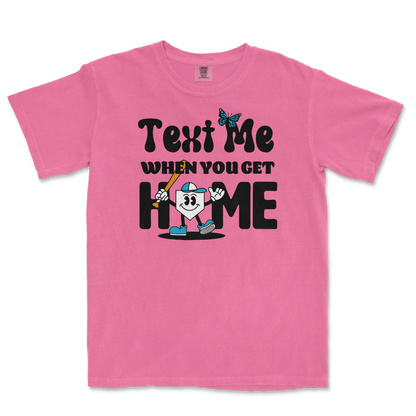 Pink T-shirt with playful black text, a cartoon character holding a baseball bat, and a butterfly graphic, with the phrase "Text me when you get home.