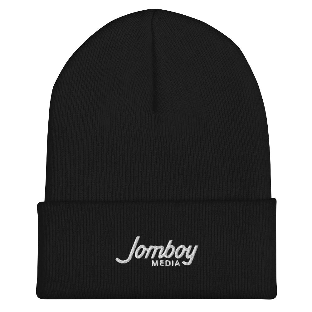 Black beanie with "Jomboy Media" embroidered in white on the front cuff, featuring a folded brim and a snug fit.