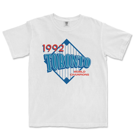 White T-shirt featuring a vintage Toronto 1992 World Champions graphic with blue, red, and white colors and a diamond-shaped design.