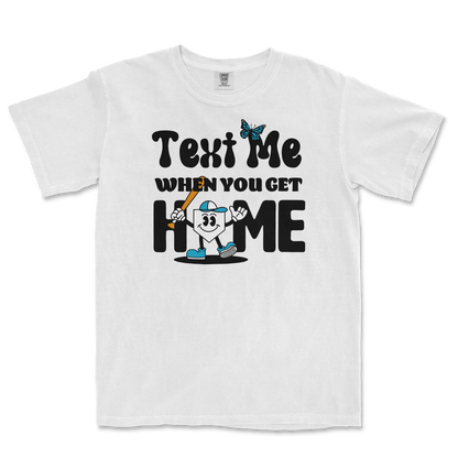 White T-shirt with a cartoon character holding a baseball bat, surrounded by playful text that says "Text Me When You Get Home.