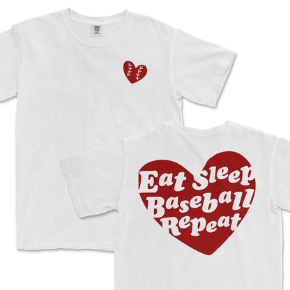 White Comfort Colors T-shirt with a small red heart graphic on the front chest and a large red heart with white "Eat Sleep Baseball Repeat" text on the back.