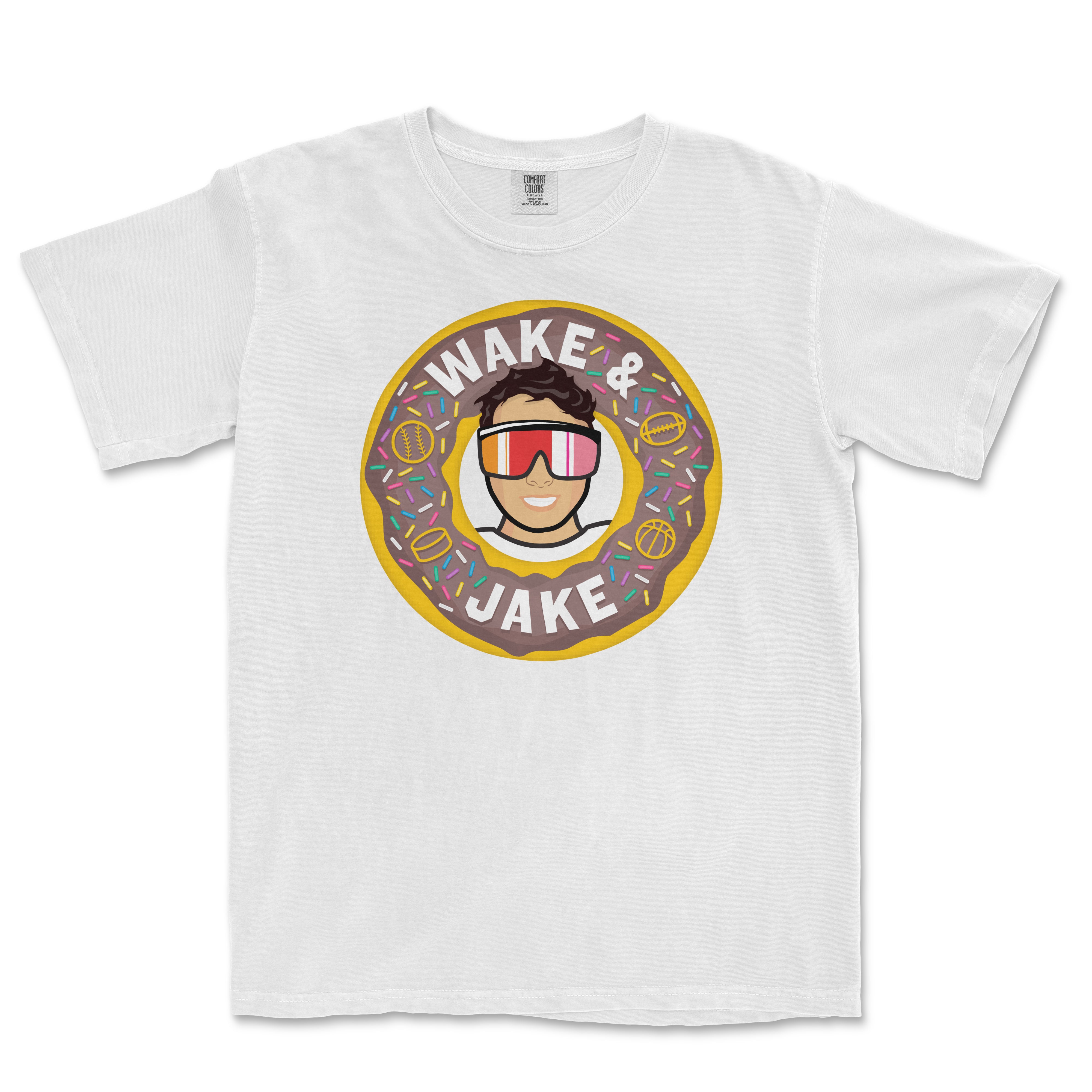 White T-shirt featuring a cartoon person wearing sunglasses inside a donut with colorful sprinkles, and the text "Wake & Jake.