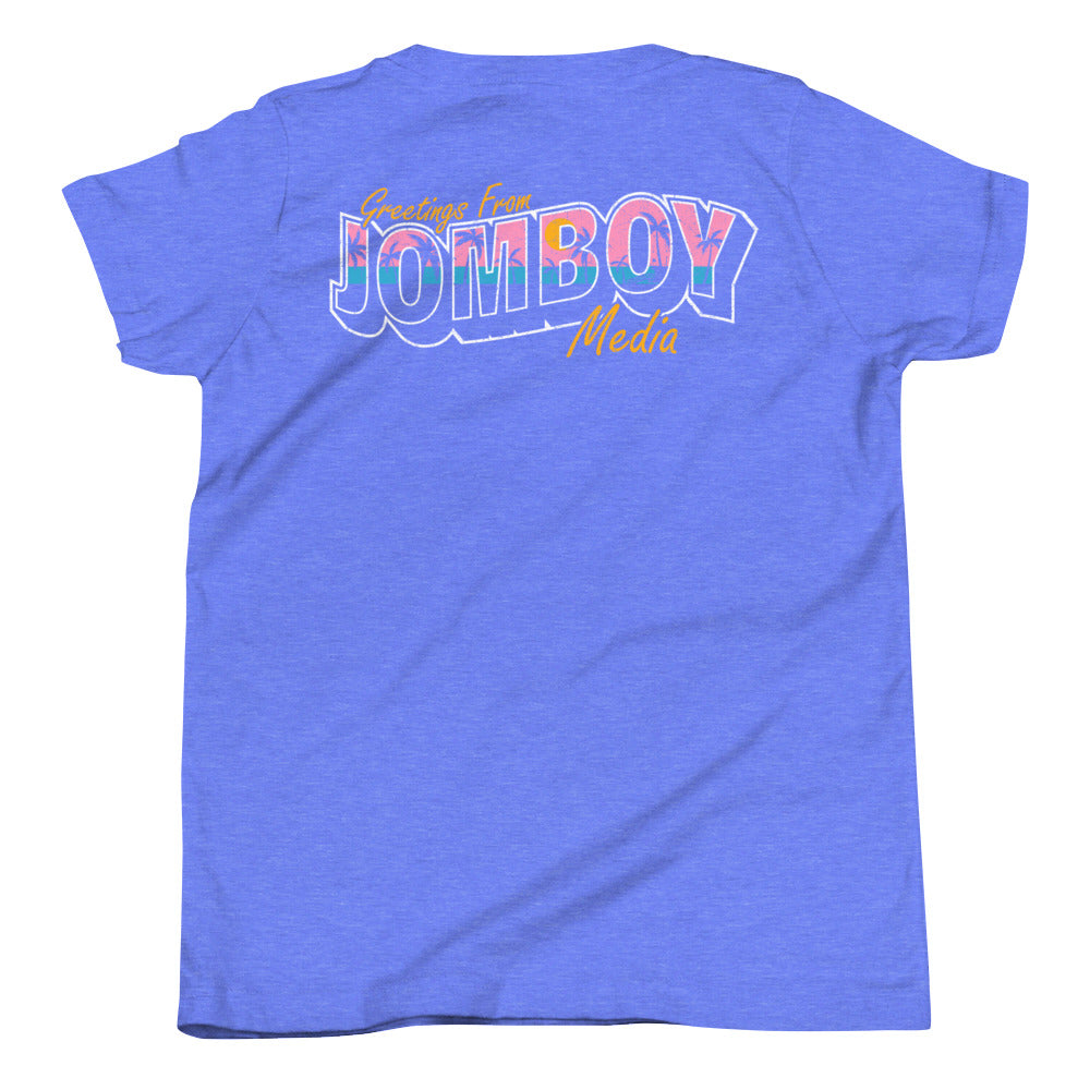 Blue youth T-shirt with colorful "Greetings from Jomboy Media" text and yellow script accents on the back.