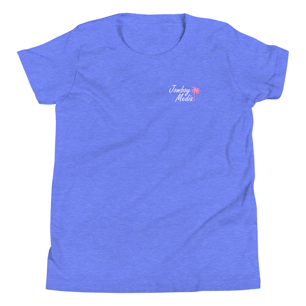 Blue youth T-shirt with "Greetings from Jomboy Media" text and a small pink palm tree graphic on the front.