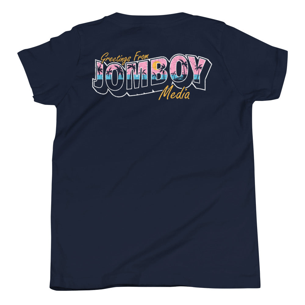 Back of navy youth T-shirt with "Greetings from Jomboy Media" in colorful, bold, and stylized text.