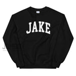 Black sweatshirt with bold white "JAKE" lettering across the chest, featuring a crew neckline and ribbed cuffs.